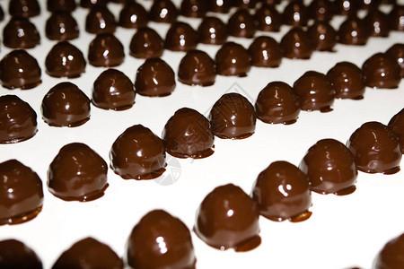 巧克力在糖果工厂的传送带上倒满了液体巧克力图片
